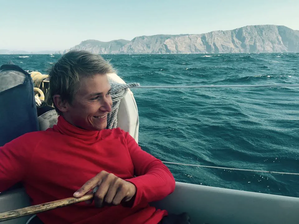 Patrik relaxing aboard a sailboat with the sea behind him